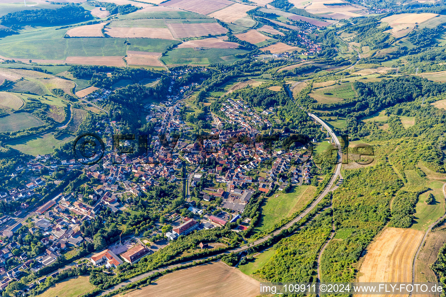 Location view of the streets and houses of residential areas in the valley landscape surrounded by mountains in Alsenz in the state Rhineland-Palatinate, Germany