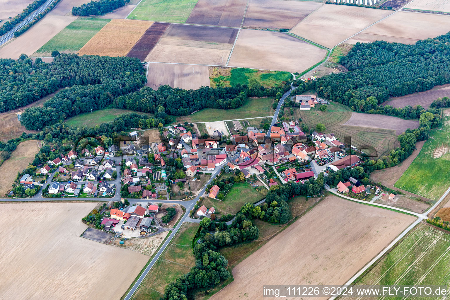 Oblique view of Agricultural land and field borders surround the settlement area of the village in Atzhausen in the state Bavaria, Germany