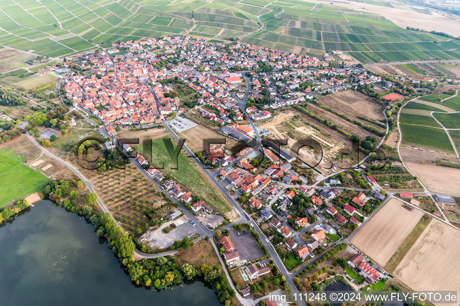 Drone recording of Agricultural land and field borders surround the settlement area of the village in Sommerach in the state Bavaria, Germany