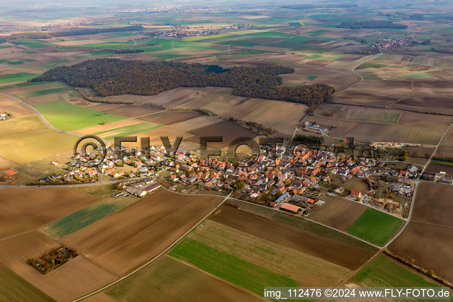 Agricultural land and field borders surround the settlement area of the village in Eichfeld in the state Bavaria, Germany