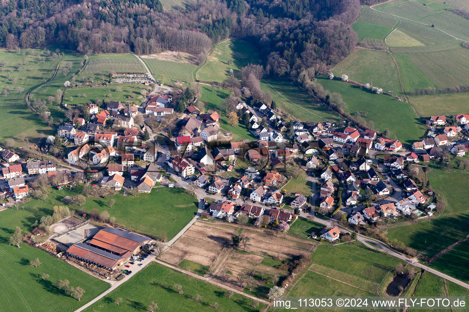 Aerial view of Agricultural land and field borders surround the settlement area of the village in Heuweiler in the state Baden-Wurttemberg, Germany