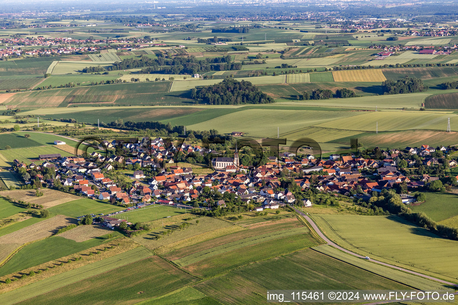 Agricultural land and field borders surround the settlement area of the village in Uhlwiller in Grand Est, France