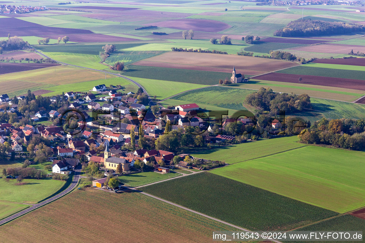 Aerial photograpy of Agricultural land and field borders surround the settlement area of the village in Bischwind in the state Bavaria, Germany