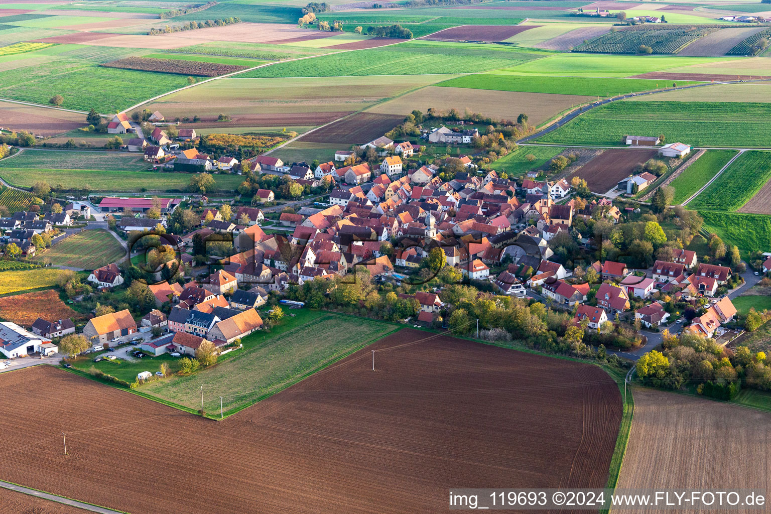 Aerial view of Agricultural land and field borders surround the settlement area of the village in Neuses a.Berg in the state Bavaria, Germany