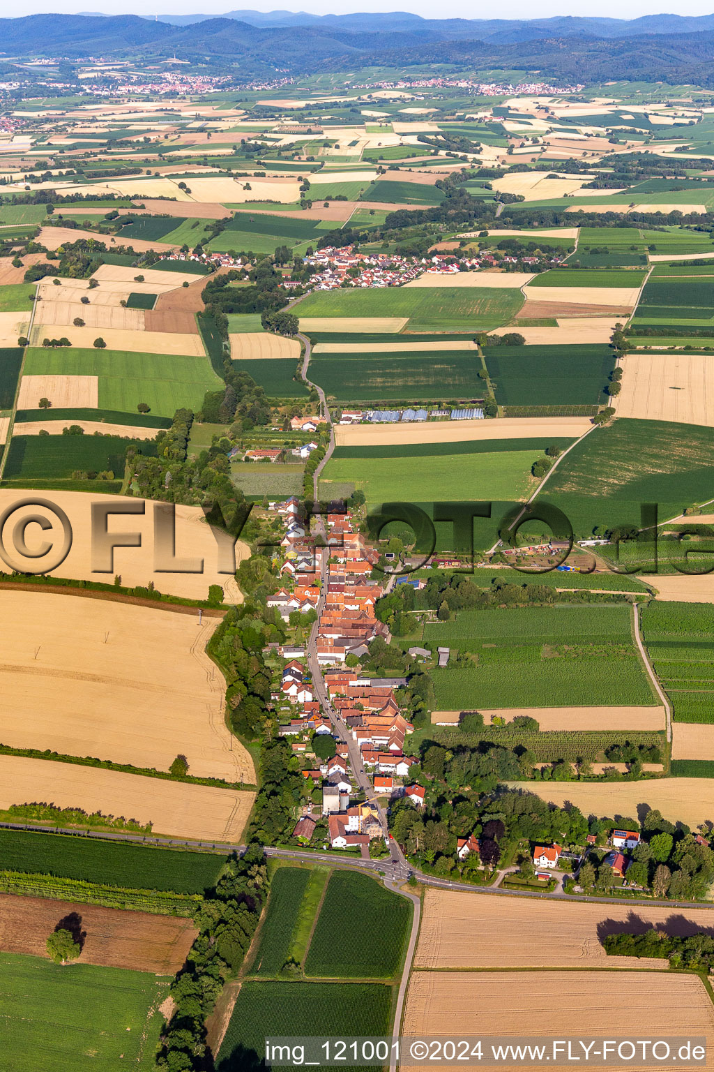 Oblique view of Agricultural land and field borders surround the settlement area of the village in Vollmersweiler in the state Rhineland-Palatinate, Germany