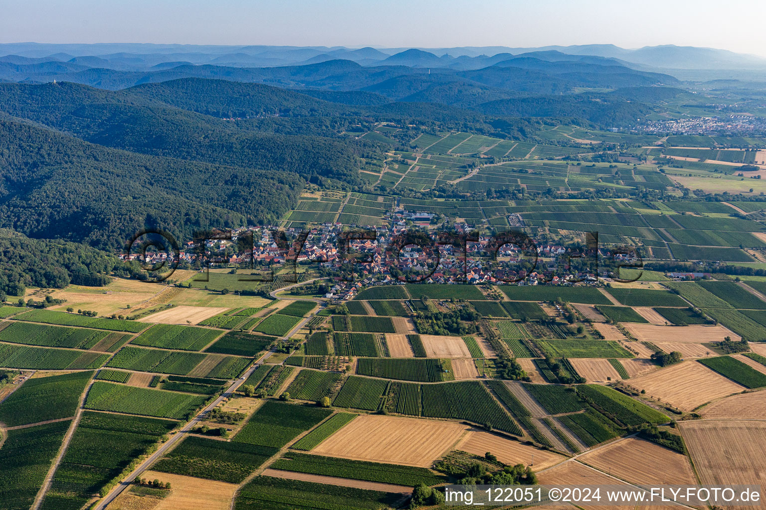 Agricultural land and field borders surround the settlement area of the village in Oberotterbach in the state Rhineland-Palatinate, Germany from a drone