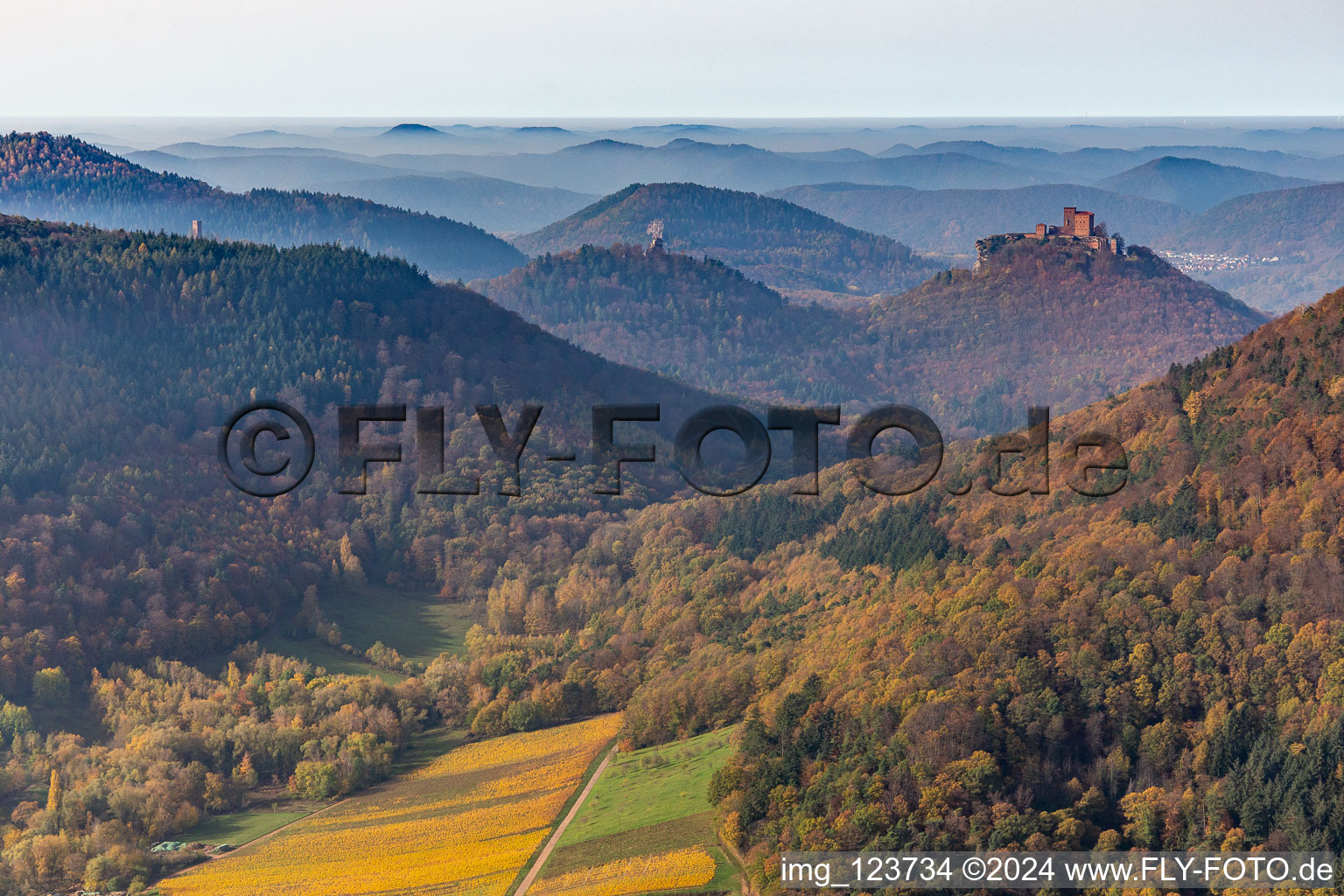 Autumnal discolored vegetation view of castle of the fortresses Trifels, Scharfeneck and Anebos at sunset in Annweiler am Trifels in the state Rhineland-Palatinate, Germany