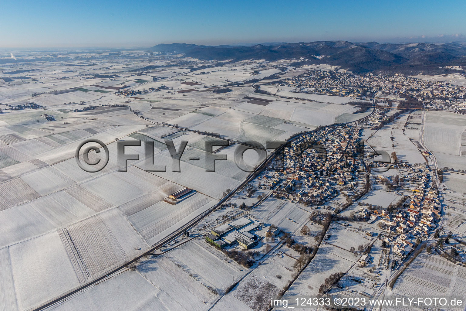 Wintry snowy village - view on the edge of agricultural fields and farmland in Niederhorbach in the state Rhineland-Palatinate, Germany