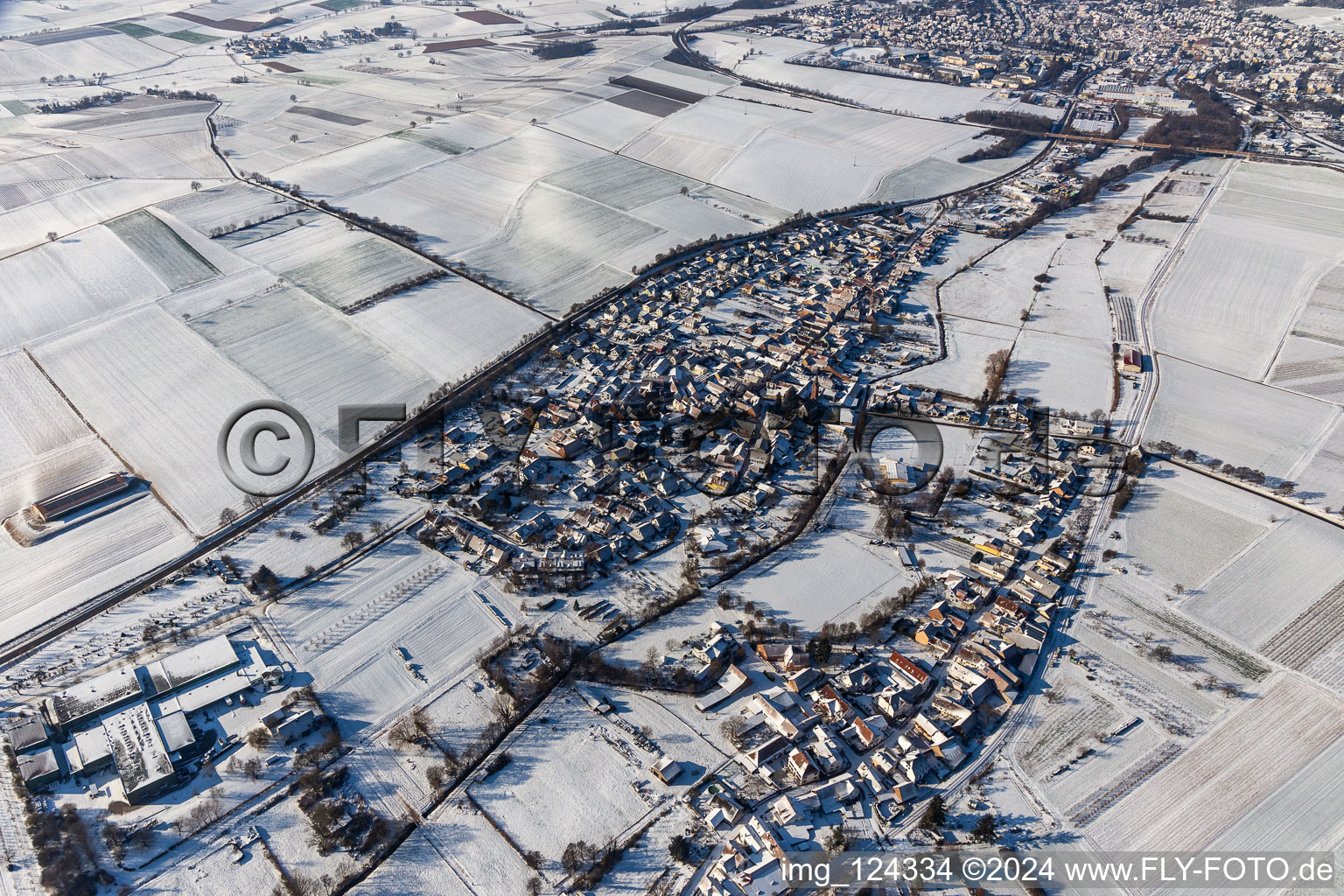 Wintry snowy village - view on the edge of agricultural fields and farmland in Niederhorbach in the state Rhineland-Palatinate, Germany