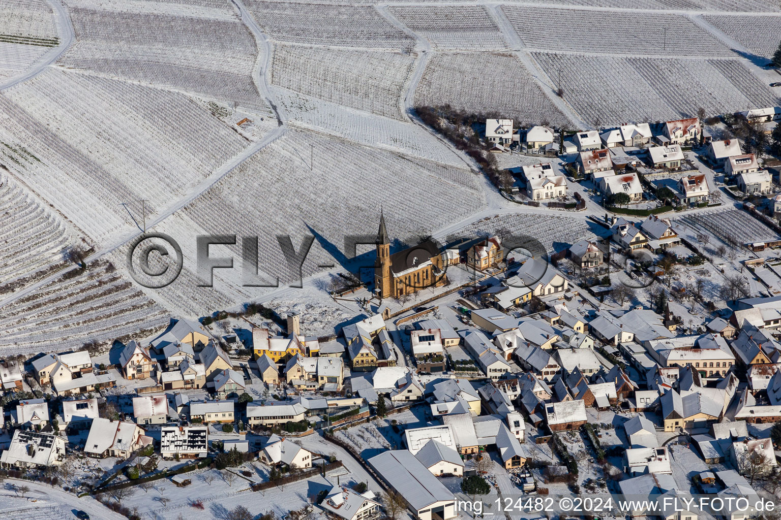 Aerial view of Wintry snowy wine yards surround the settlement area of the village in Birkweiler in the state Rhineland-Palatinate, Germany