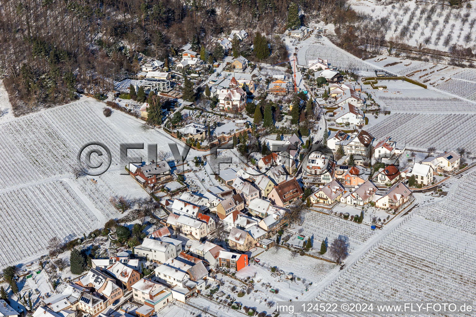 Aerial view of Wintry snowy village on the edge of vineyards and wineries in the wine-growing area in Weyher in der Pfalz in the state Rhineland-Palatinate, Germany