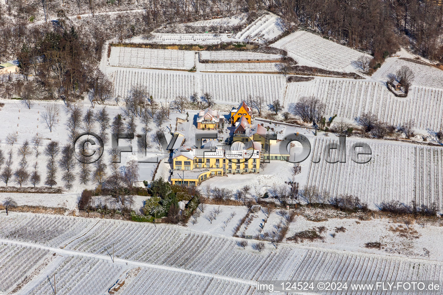 Wintry snowy complex of the hotel building Wohlfuehlhotel Alte Rebschule and Gasthaus Sesel in springtime in Rhodt unter Rietburg in the state Rhineland-Palatinate, Germany