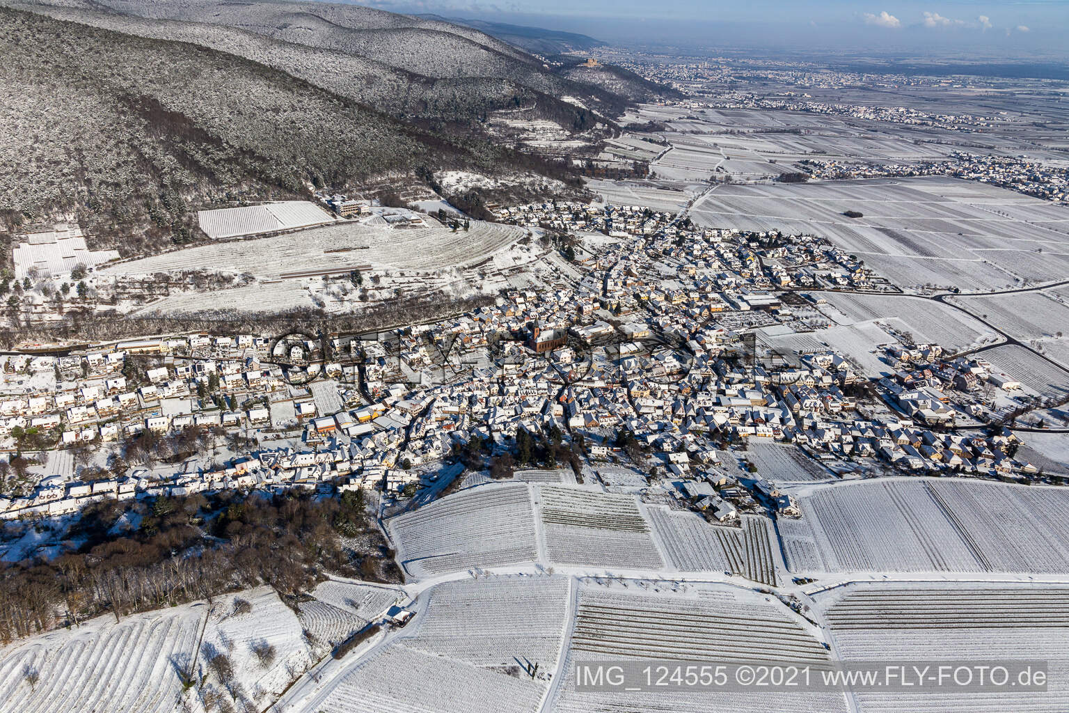 Wintry snowy village - view on the edge of agricultural fields and farmland in Sankt Martin in the state Rhineland-Palatinate, Germany