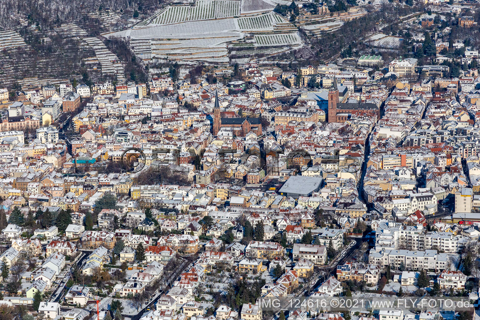 Winter aerial view in the snow with Catholic parish church of St. Mary and Protestant collegiate church in Neustadt an der Weinstraße in the state Rhineland-Palatinate, Germany