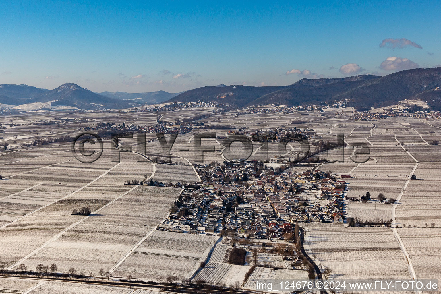 Aerial view of Wintry snowy village - view on the edge of agricultural fields and farmland in Roschbach in the state Rhineland-Palatinate, Germany