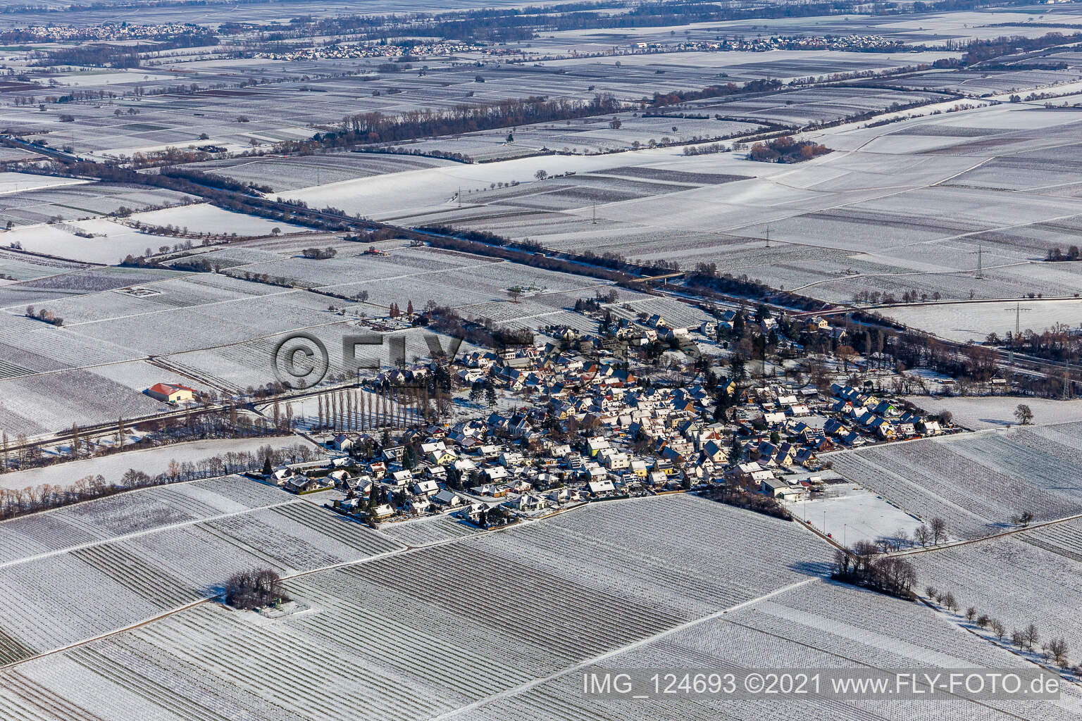Aerial view of Wintry snowy village - view on the edge of agricultural fields and farmland in Knoeringen in the state Rhineland-Palatinate, Germany