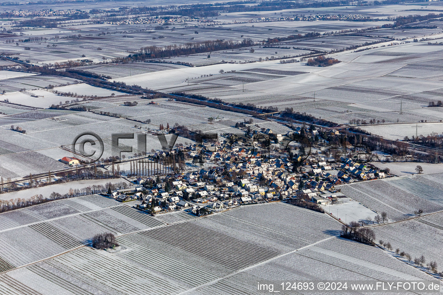 Aerial view of Wintry snowy village - view on the edge of agricultural fields and farmland in Knoeringen in the state Rhineland-Palatinate, Germany