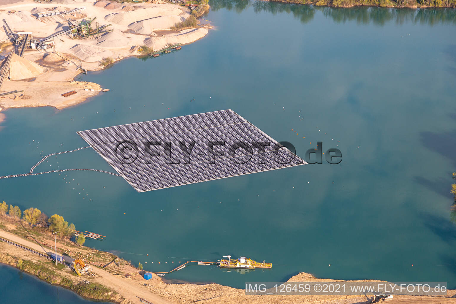 Aerial photograpy of Floating solar power plant and panels of photovoltaic systems on the surface of the water on a quarry pond for gravel extraction in Leimersheim in the state Rhineland-Palatinate, Germany
