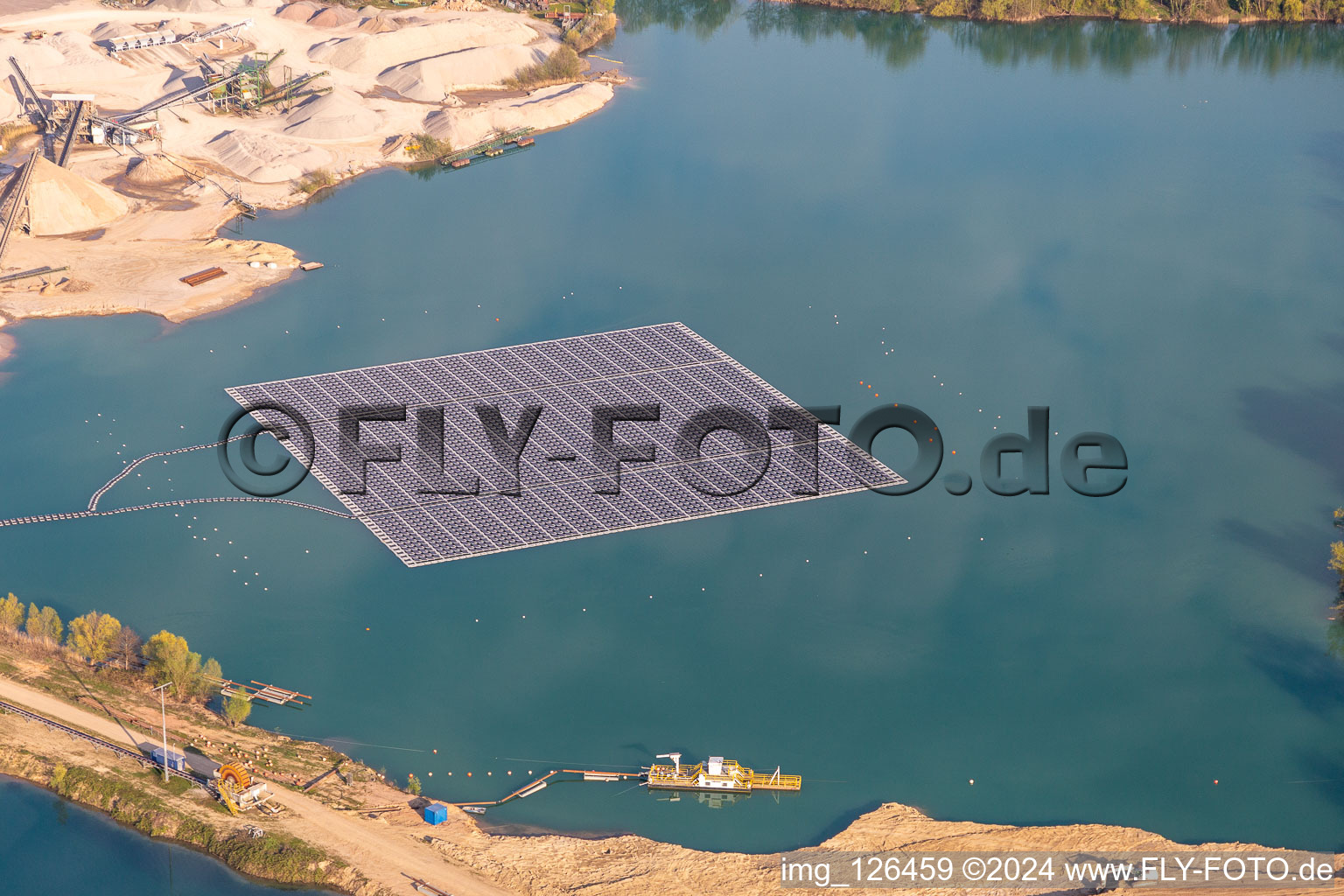 Aerial photograpy of Floating solar power plant and panels of photovoltaic systems on the surface of the water on a quarry pond for gravel extraction in Leimersheim in the state Rhineland-Palatinate, Germany