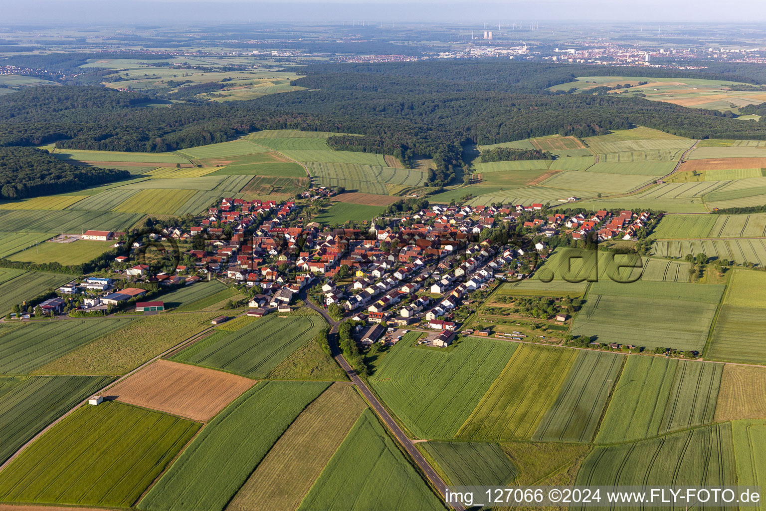 Aerial view of Agricultural land and field boundaries surround the settlement area of the village in Hesselbach in the state Bavaria, Germany