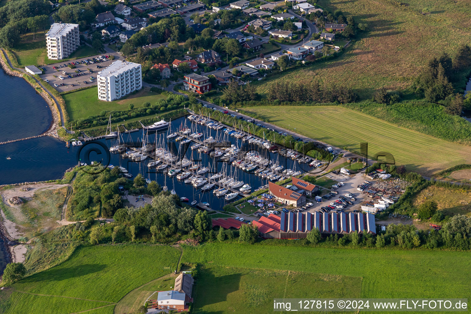 Aerial view of Pleasure boat marina of CLUB NAUTIC e.V. with docks and moorings on the shore area of the Foerde with Restaurant "Leuchtturm" in Schausende in Gluecksburg in the state Schleswig-Holstein, Germany