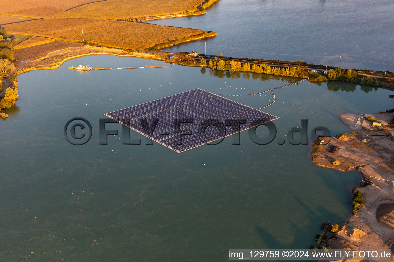 Oblique view of Floating solar power plant and panels of photovoltaic systems on the surface of the water on a quarry pond for gravel extraction in Leimersheim in the state Rhineland-Palatinate, Germany