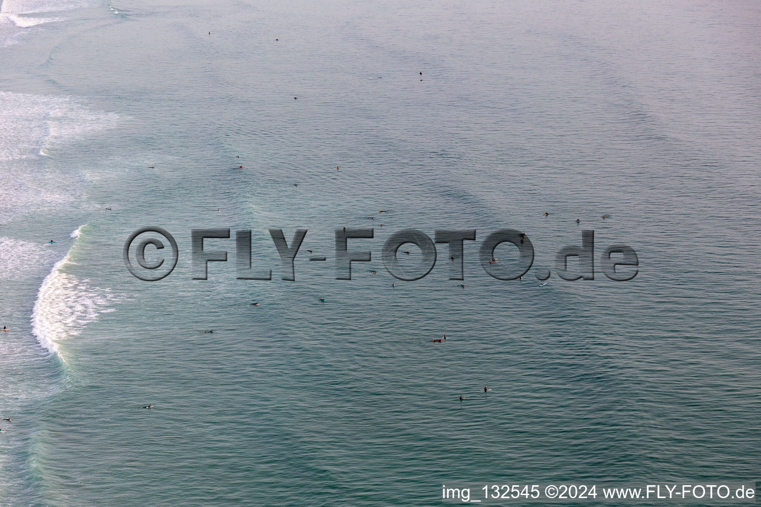 Surfers waiting for the wave in front of the Plage de Tronoën in Saint-Jean-Trolimon in the state Finistere, France