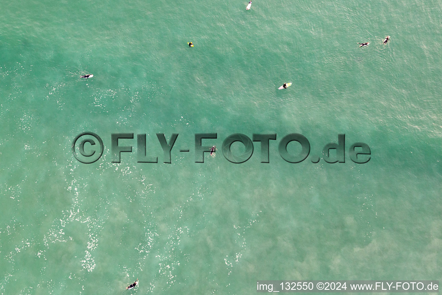 Aerial view of Surfers waiting for the wave in front of the Plage de Tronoën in Saint-Jean-Trolimon in the state Finistere, France