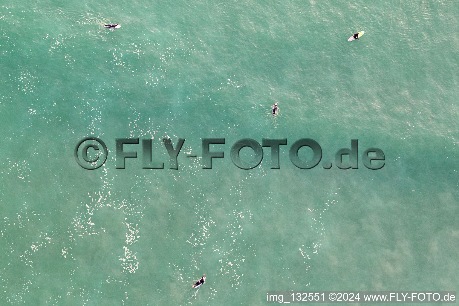 Aerial photograpy of Surfers waiting for the wave in front of the Plage de Tronoën in Saint-Jean-Trolimon in the state Finistere, France