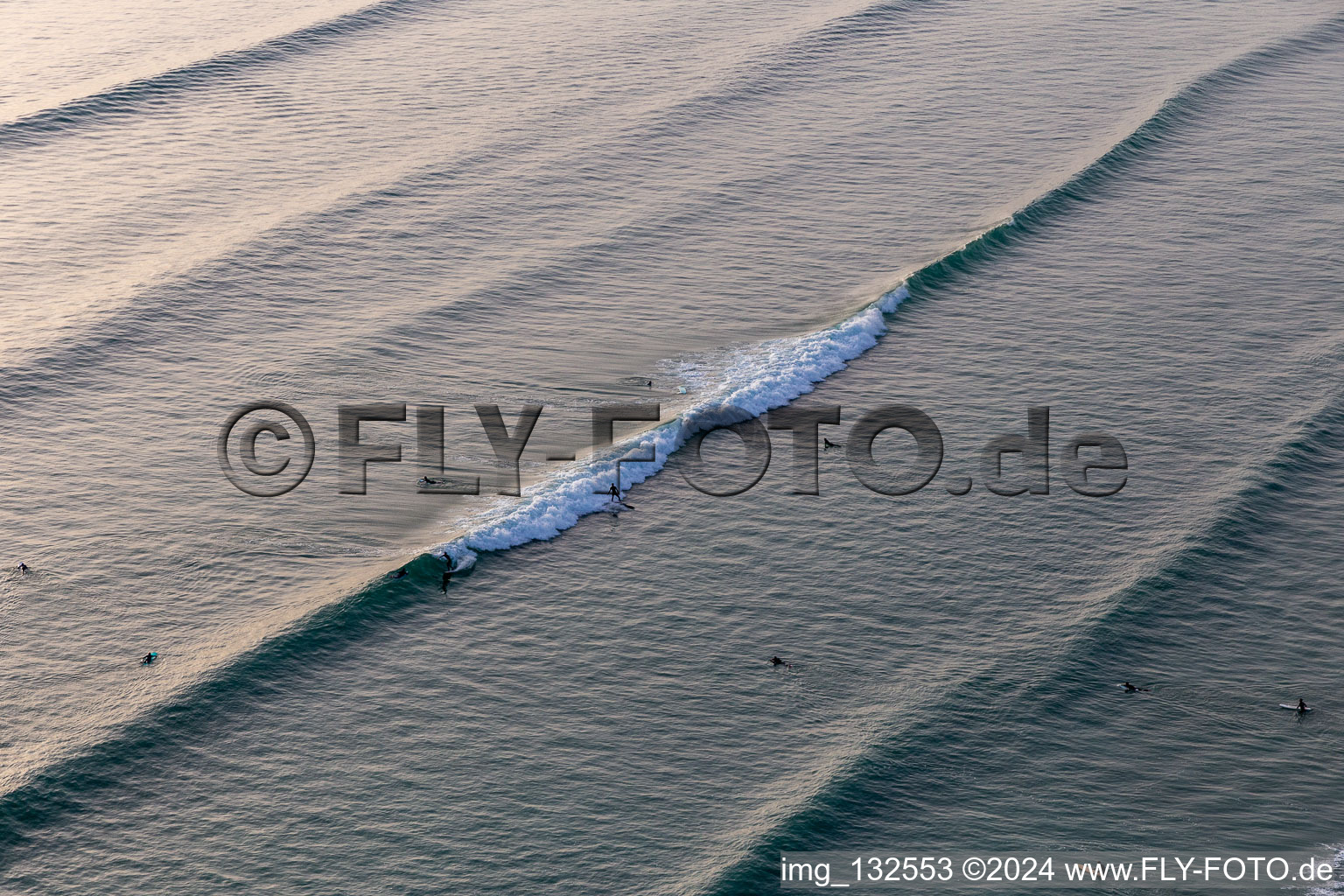 Wave surfers in front of the Plage de Tronoën in Saint-Jean-Trolimon in the state Finistere, France