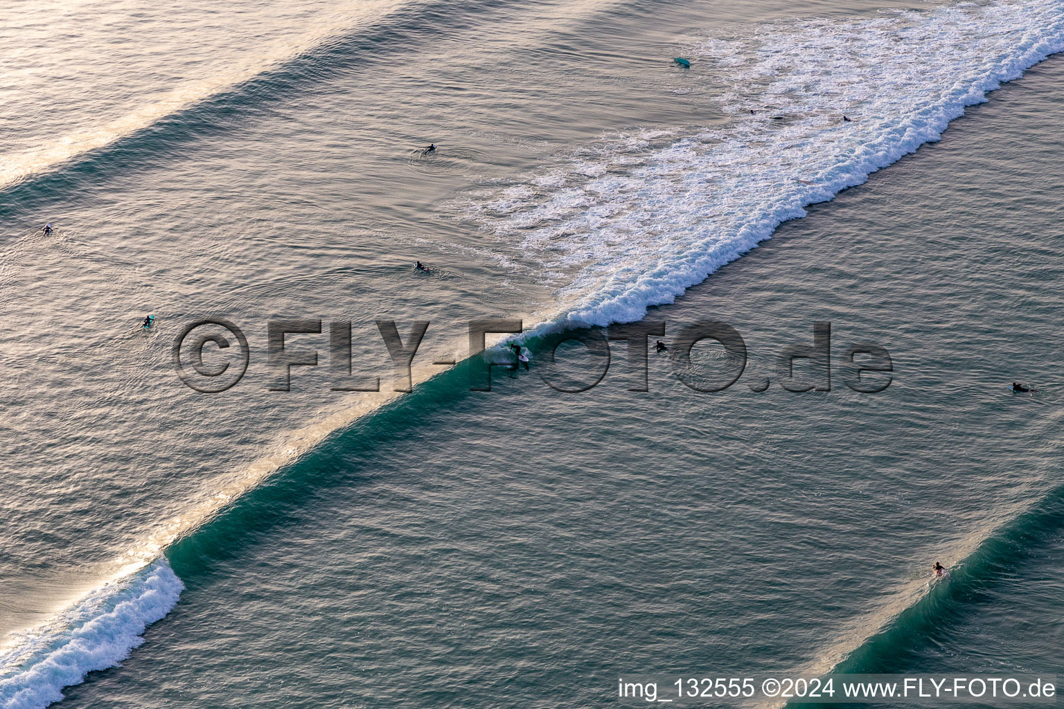 Aerial photograpy of Wave surfers in front of the Plage de Tronoën in Saint-Jean-Trolimon in the state Finistere, France