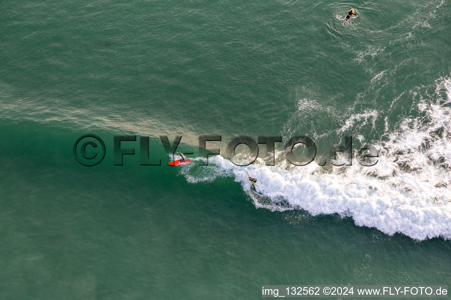 Bird's eye view of Wave surfers in front of the Plage de Tronoën in Saint-Jean-Trolimon in the state Finistere, France