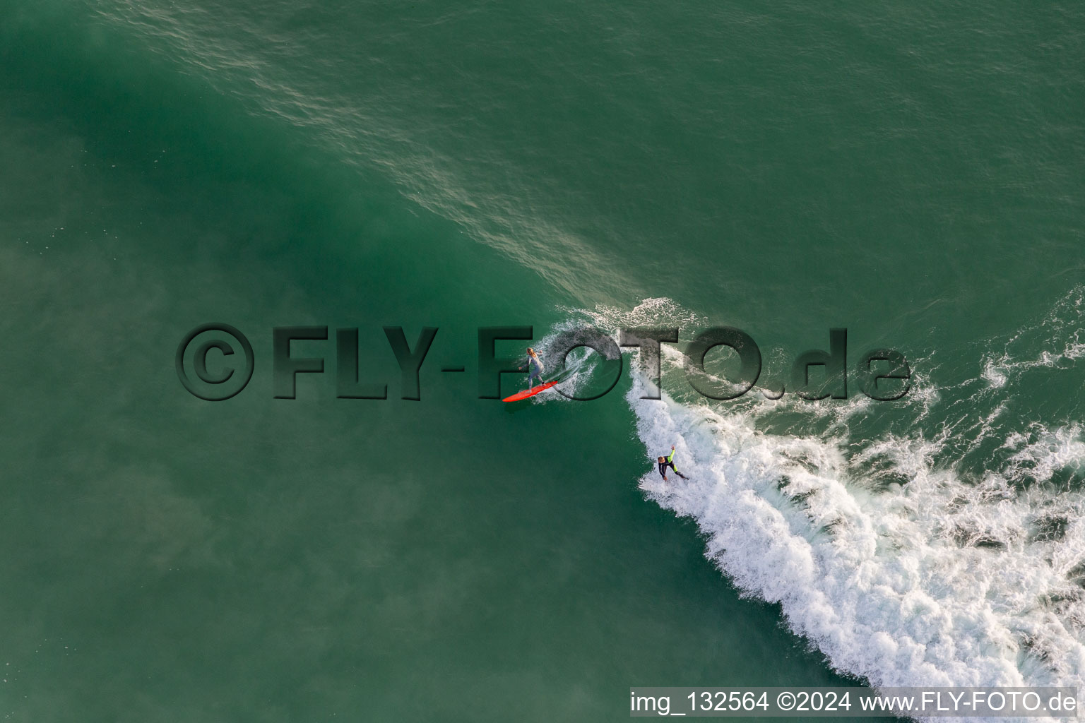 Drone recording of Wave surfers in front of the Plage de Tronoën in Saint-Jean-Trolimon in the state Finistere, France