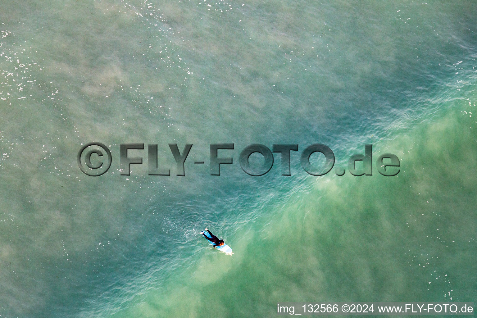 Drone image of Wave surfers in front of the Plage de Tronoën in Saint-Jean-Trolimon in the state Finistere, France