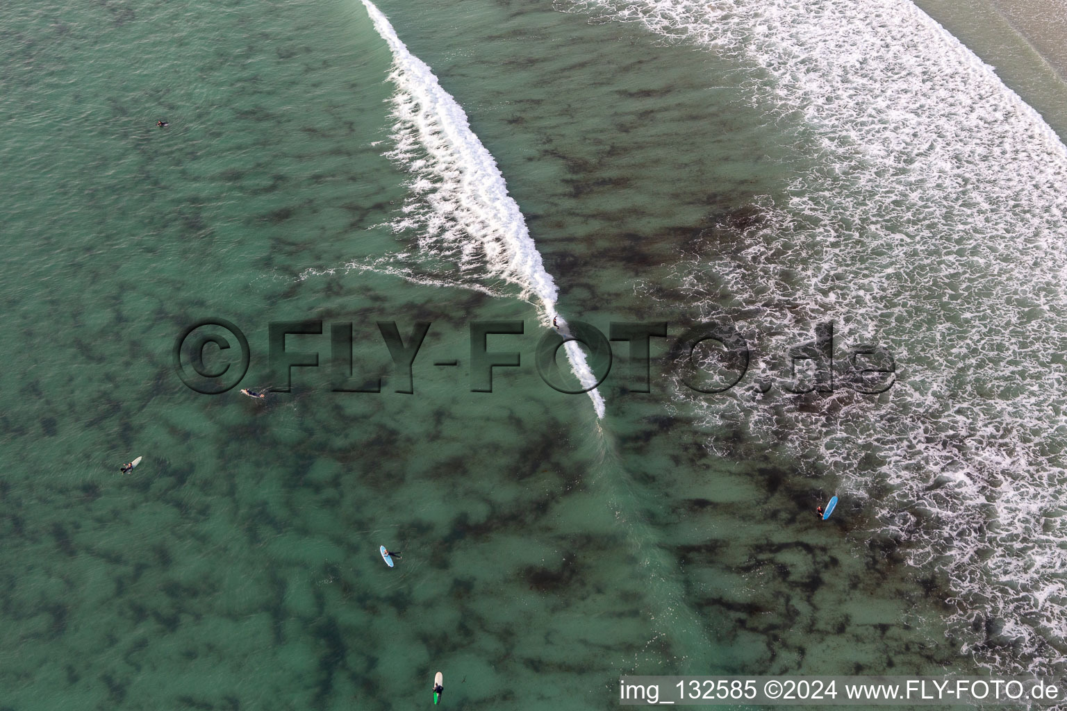 Aerial view of Wave surfers in front of Plage la Torche-Tronoën in Plomeur in the state Finistere, France