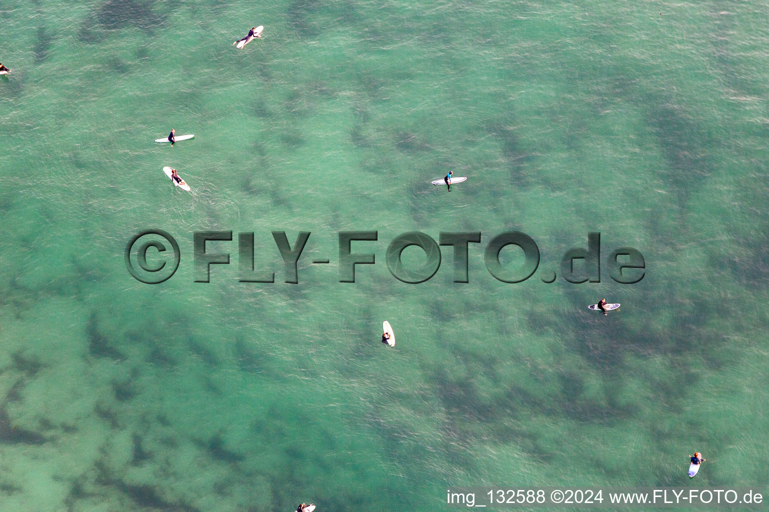 Surfers waiting for the wave in front of the Plage la Torche-Tronoën in Plomeur in the state Finistere, France