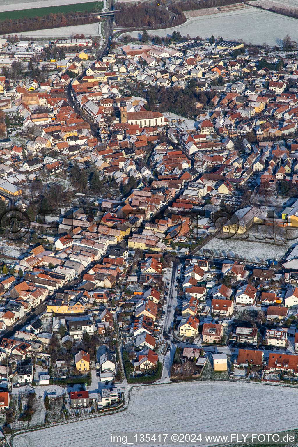 Aerial view of Main street with parish church of St. Michael in winter with snow in Rheinzabern in the state Rhineland-Palatinate, Germany