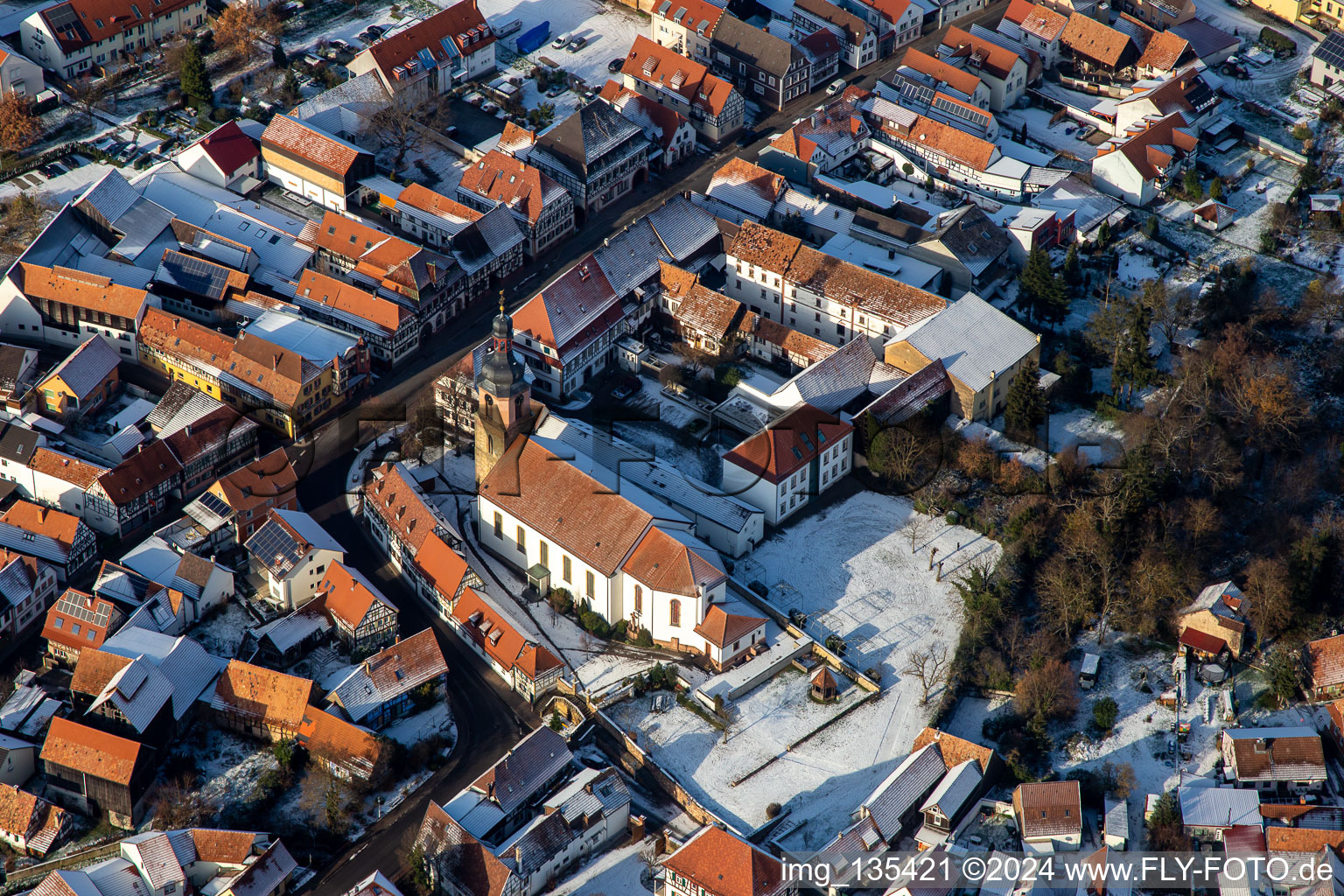 Main street with parish church of St. Michael in winter with snow in Rheinzabern in the state Rhineland-Palatinate, Germany out of the air