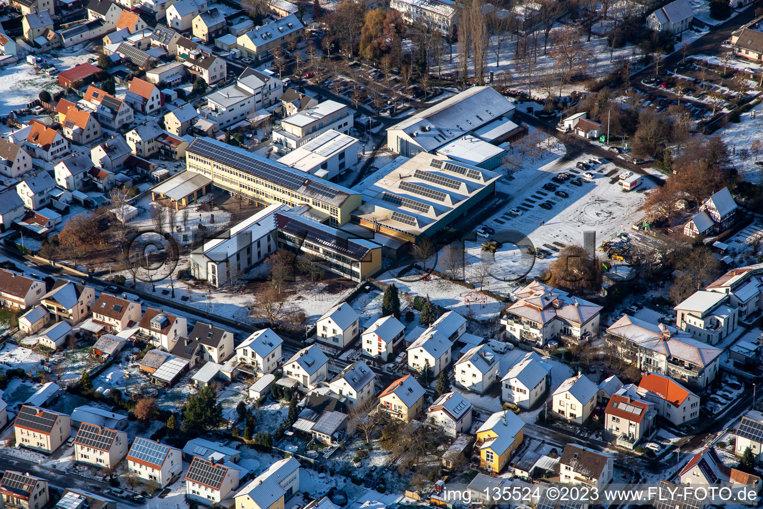 Primary school and fairground in winter with snow in the district Herxheim in Herxheim bei Landau in the state Rhineland-Palatinate, Germany