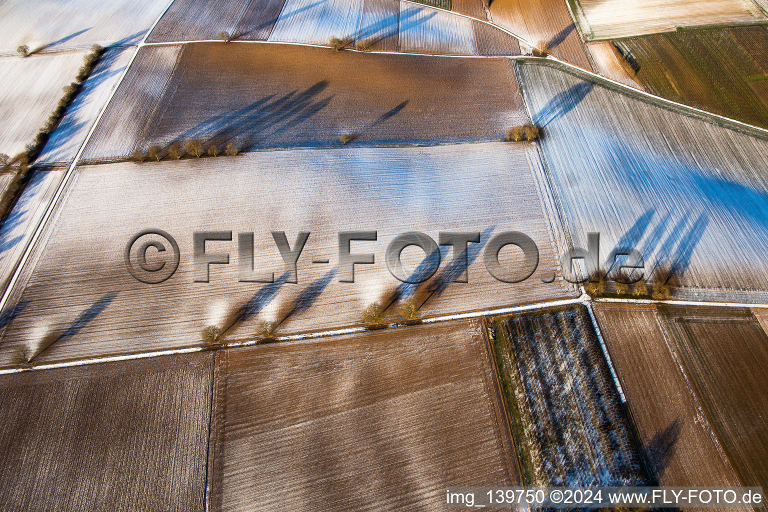 Aerial view of Field structures and shadows in winter with snow in Vollmersweiler in the state Rhineland-Palatinate, Germany