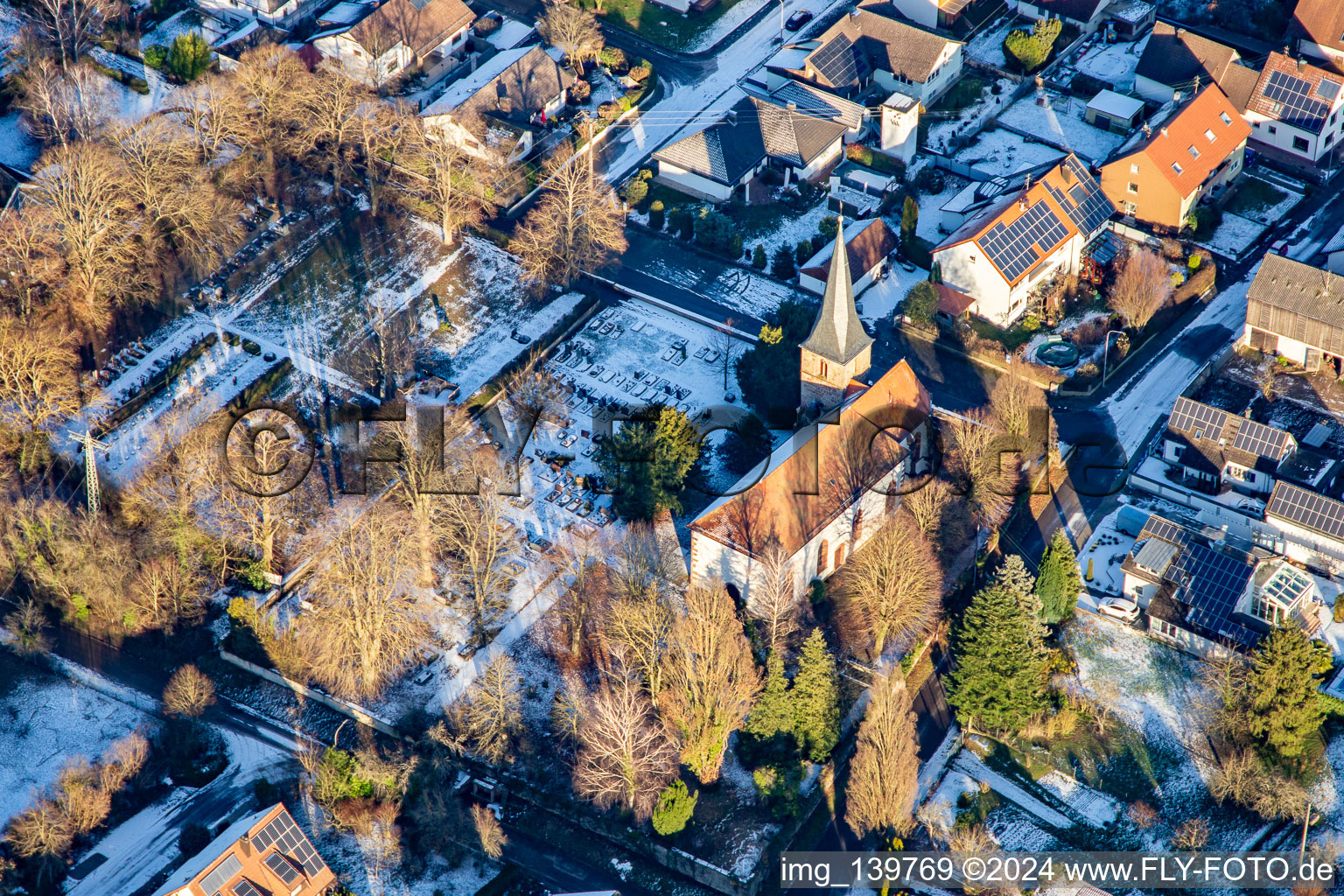 Wolfgang's Church and cemetery in winter with snow in Freckenfeld in the state Rhineland-Palatinate, Germany