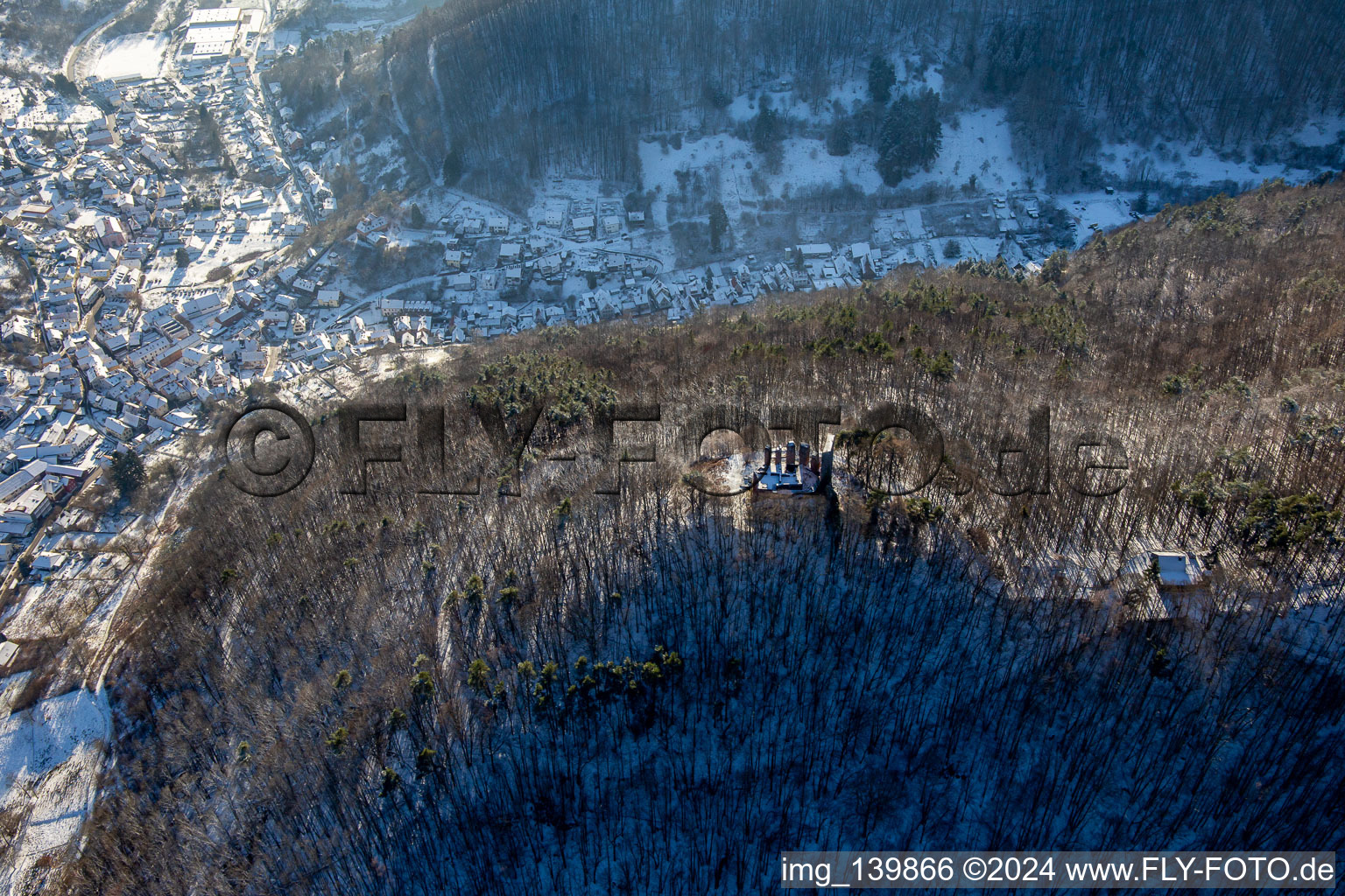 Ramburg castle ruins in winter with snow in Ramberg in the state Rhineland-Palatinate, Germany from above