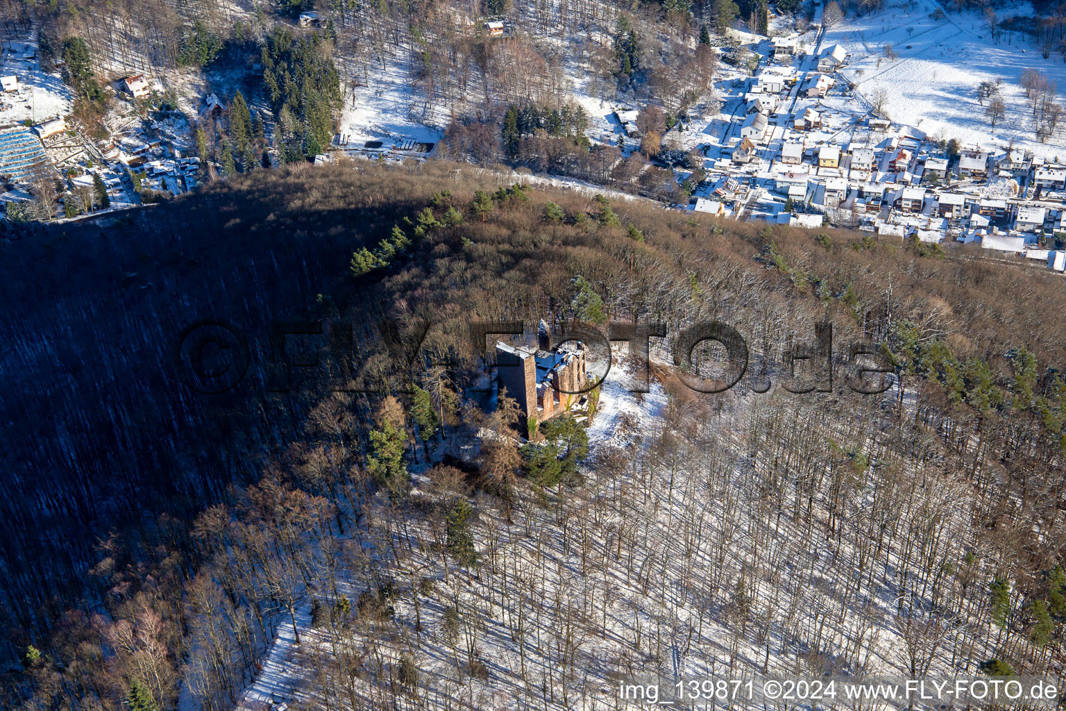 Ramburg castle ruins in winter with snow in Ramberg in the state Rhineland-Palatinate, Germany seen from above