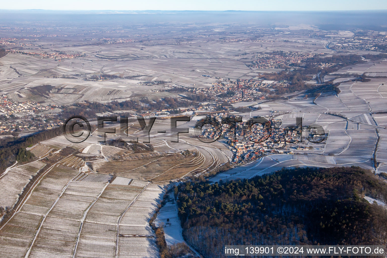 Aerial view of Keschdebusch vineyard from the west in winter with snow in Birkweiler in the state Rhineland-Palatinate, Germany