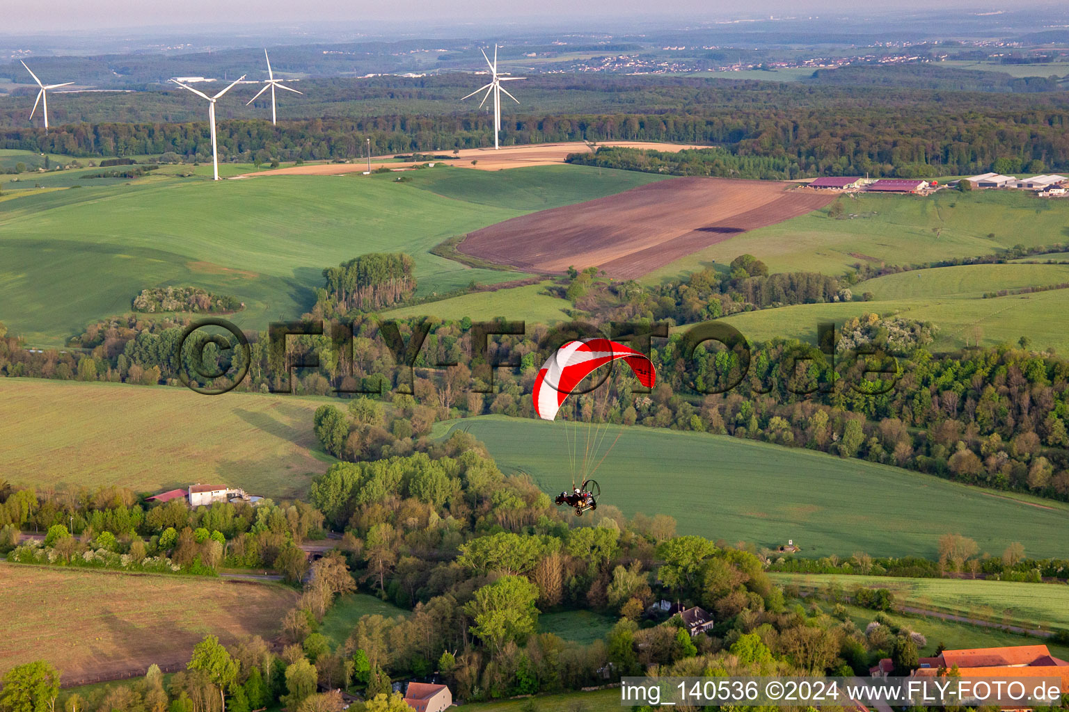 Paramotor in front of wind farm in Herbitzheim in the state Bas-Rhin, France