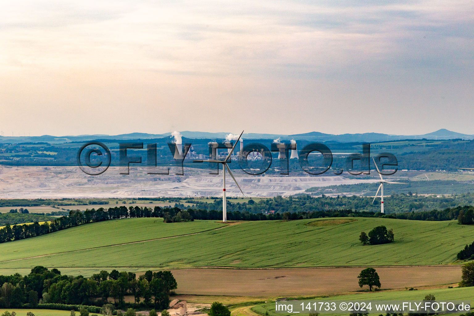 Oblique view of Czech wind farm Wetzwalde (Větrný park Václavice) in front of the Polish brown coal open-cast mine Kopalnia Węgla Brunatnego Turów in Hrádek nad Nisou in the state Liberec, Czech Republic