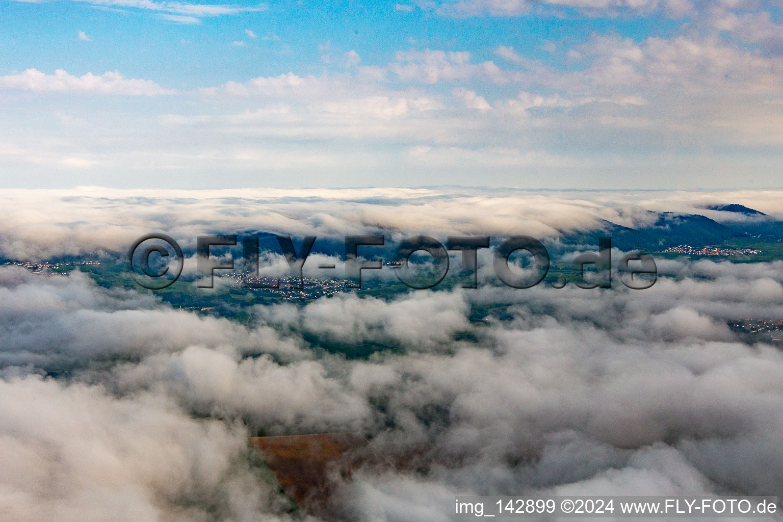 Village on the edge of the Pfläzerwald from the southeast under low clouds in Klingenmünster in the state Rhineland-Palatinate, Germany