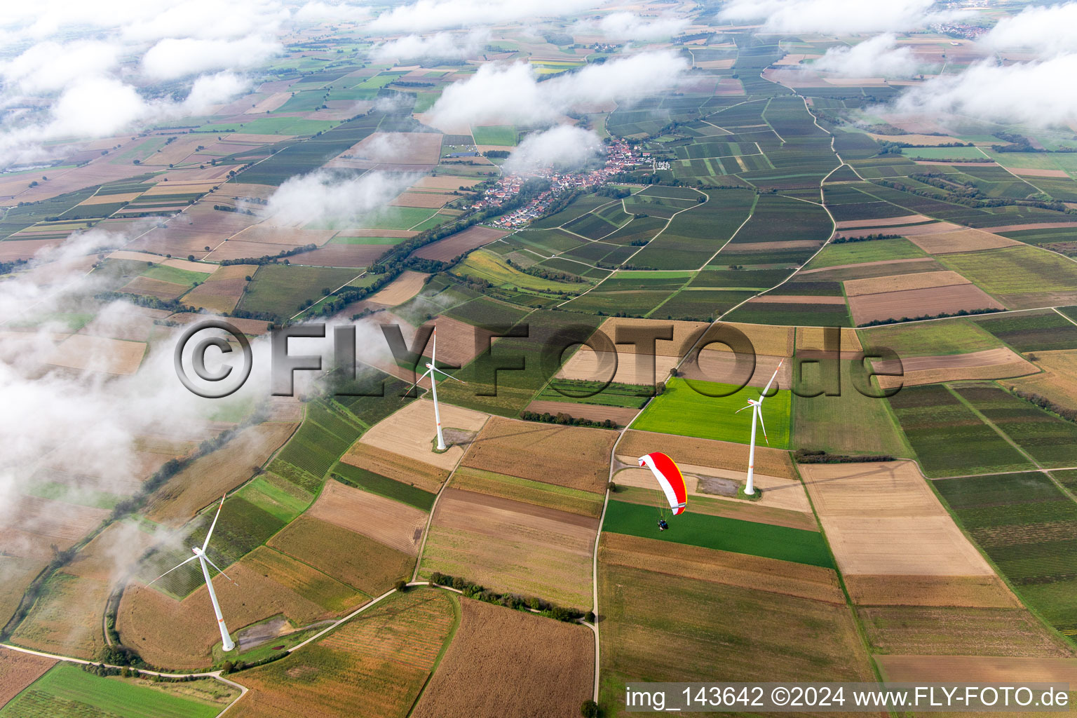 Aerial view of Paraglider over the wind farm Freckenfeld in clouds in Freckenfeld in the state Rhineland-Palatinate, Germany
