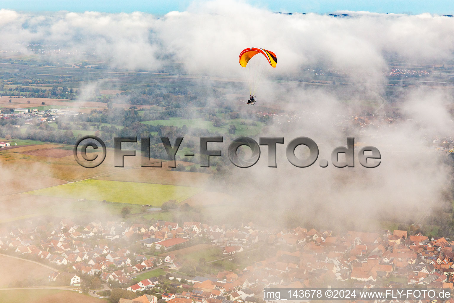 Aerial view of Village with paraglider under autumn clouds in Steinweiler in the state Rhineland-Palatinate, Germany