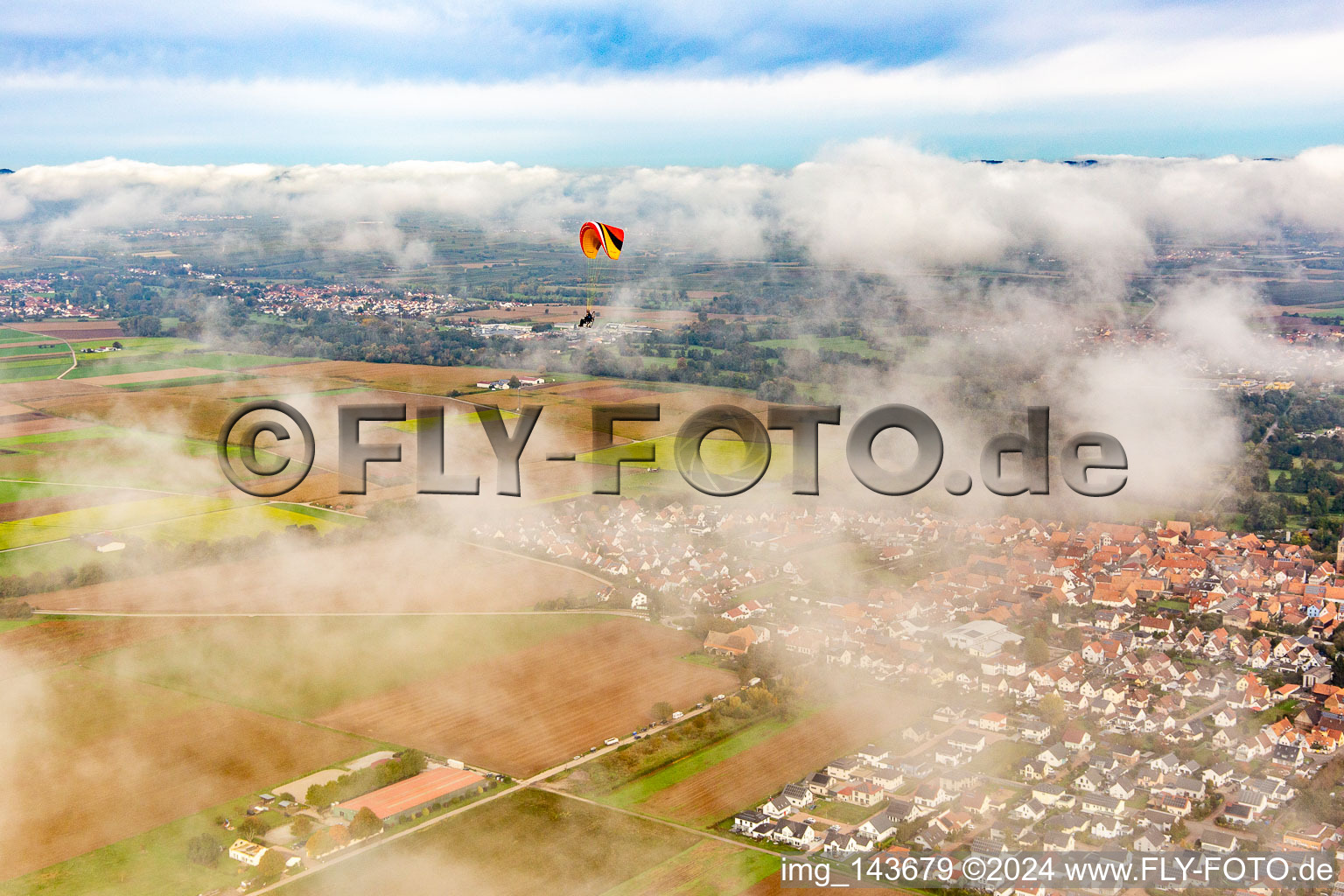 Aerial photograpy of Village with paraglider under autumn clouds in Steinweiler in the state Rhineland-Palatinate, Germany